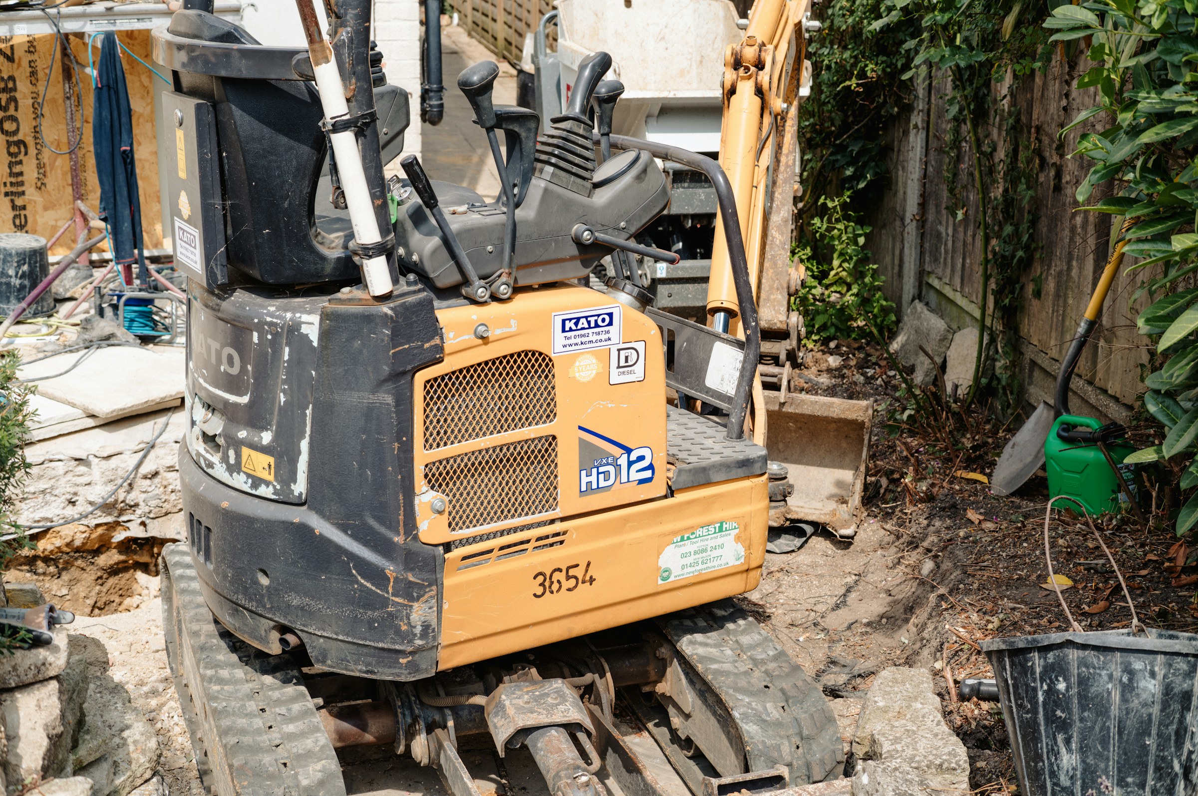 Mini-pelle compacte travaillant dans un jardin